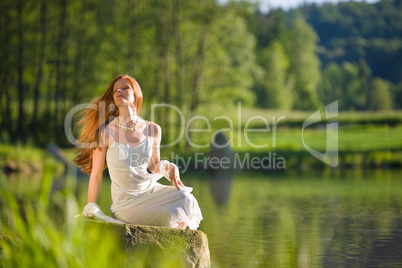 Long red hair romantic woman relax by lake