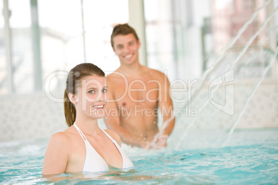 Young sportive couple have fun in pool, focus on woman