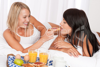 Two young women eating toast with marmalade