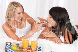 Two young women eating toast with marmalade