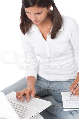 Teenager with laptop writing notes