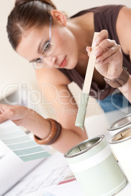 Female designer with can of paint at office