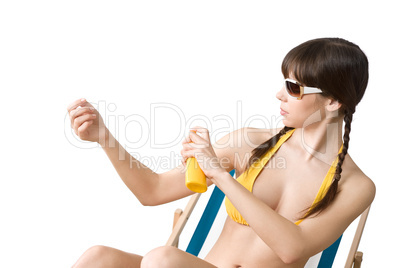 Beach - woman in bikini apply suntan lotion