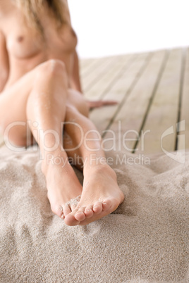 Naked woman sunbathing on beach