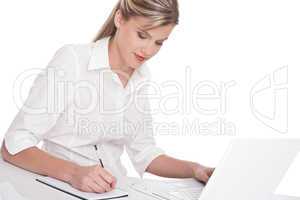 Woman working with laptop and writing notes