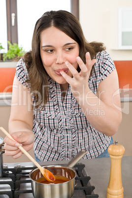 Cook - plus size woman tasting Italian tomato sauce