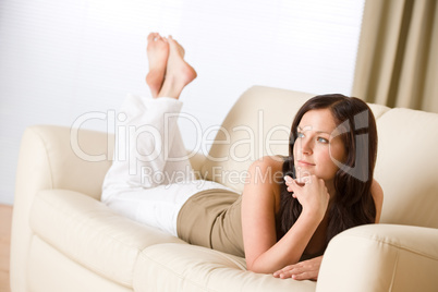 Young happy woman relax lying down on sofa