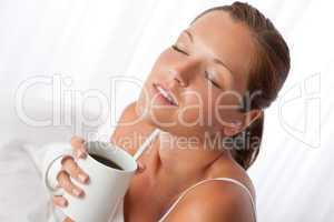 Beautiful young woman holding cup of coffee