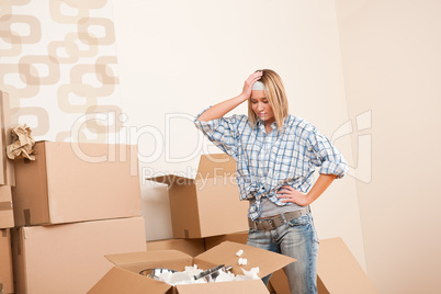 Moving house: Young woman unpacking box