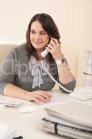 Smiling secretary on phone at office