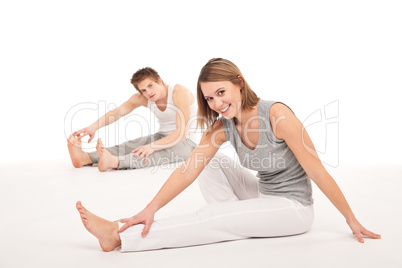 Fitness - Healthy couple stretching after training on white