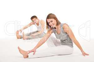 Fitness - Healthy couple stretching after training on white