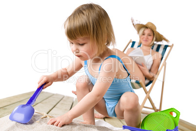 Beach - Mother with child playing with toys in sand