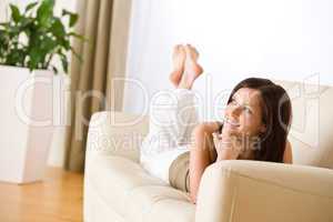 Young woman relax lying down on sofa