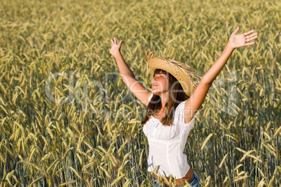 Happy woman with straw hat enjoy sun in field
