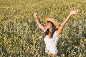 Happy woman with straw hat enjoy sun in field