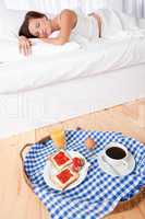 Woman having homemade breakfast lying in bed