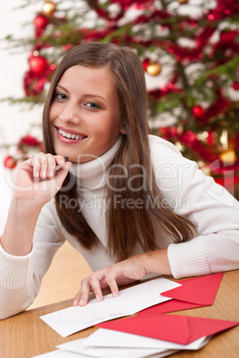 Young woman writing Christmas card