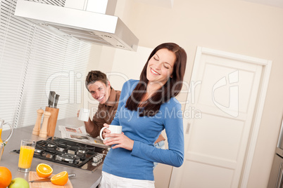 Smiling woman having coffee in the kitchen