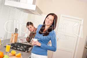 Smiling woman having coffee in the kitchen