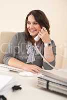 Smiling secretary on phone at office