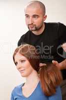 Professional hairdresser with long red hair customer at salon