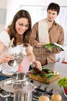 Happy couple cook in kitchen with cookbook