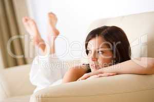 Thoughtful woman relax in lounge on sofa