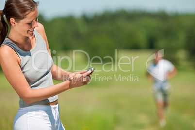 Smiling woman with stopwatch measuring time