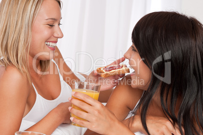 Two young women having fun by breakfast