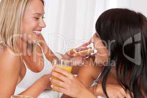 Two young women having fun by breakfast