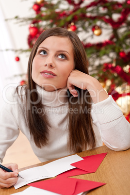 Young woman writing Christmas card