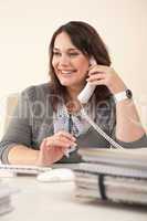 Smiling secretary on phone at office