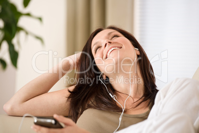 Woman holding music player listening in lounge