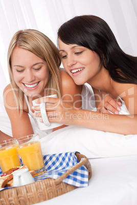 Two young smiling women having breakfast