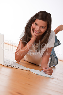 Smiling teenager lying down with laptop