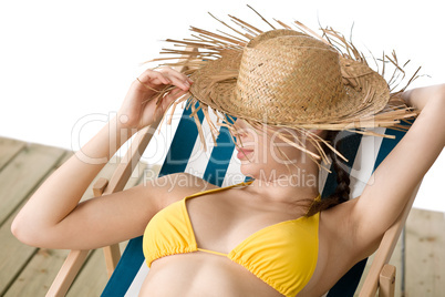 Beach - woman with straw hat in yellow bikini sunbath