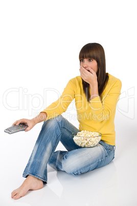 Surprised female teenager watching television