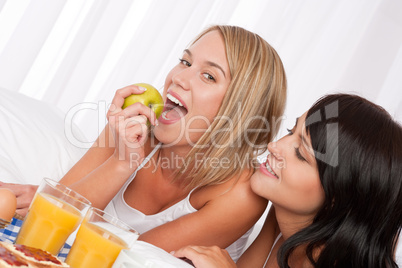 Blond woman and brunette having breakfast