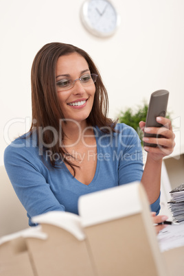 Young female architect working at office holding phone