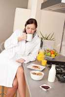 Young woman enjoying coffee in kitchen