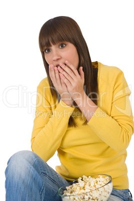 Surprised female teenager watching television