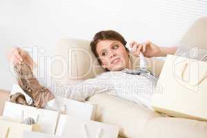 Young business woman with shopping bag on sofa