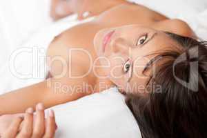 Portrait of brown hair naked woman in white bed