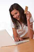 Happy teenager with laptop holding protein bar