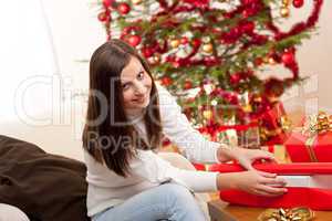 Happy woman wrapping Christmas present