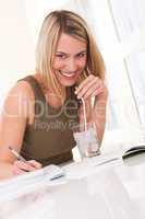 Student series - Young blond woman writing homework