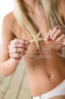 Topless woman holding starfish