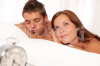 Young couple lying in white bed