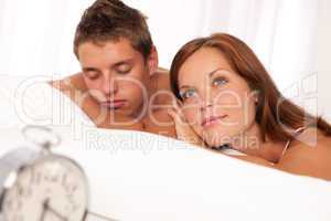 Young couple lying in white bed
